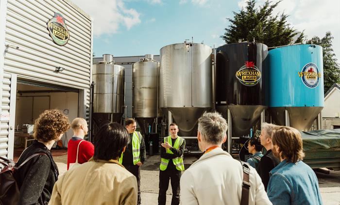 A group of people on a tour at a lager making attraction.